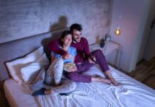 Cum să mobilezi dormitorul pentru propriul home cinema Couple watching TV in bed
