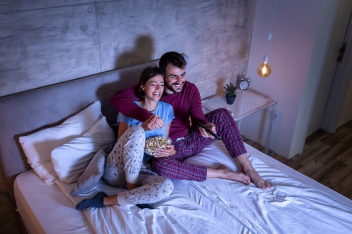Couple watching TV in bed